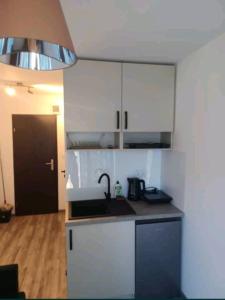 a kitchen with white cabinets and a sink at Pokój u Julii in Okuninka