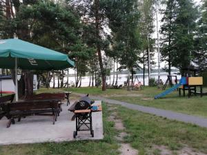 a park with a grill and picnic tables and a playground at Pokój u Julii in Okuninka