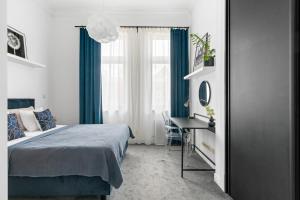 a bedroom with a bed and a desk and a window at AS HOME Apartamenty - Grand Designer Loft 90m2 RYNEK 505 in Wrocław