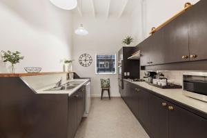 a kitchen with dark brown cabinets and a sink at The Habeke Haven in Queenstown