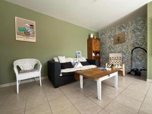 un soggiorno con un divano e un tavolo di Le cottage de Mag a Cerences