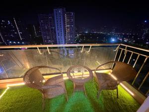 three chairs and a table on a balcony at night at Atha luxury studio 02 in Jāmb +10 photos