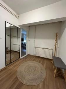 a room with a rug on the floor and a table and a mirror at Aurora Plitvice in Smoljanac