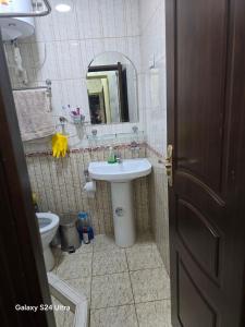 a bathroom with a sink and a toilet and a mirror at Festival Suites Ferghana in Fergana