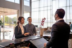 迪沙鲁Four Points by Sheraton Desaru的一群人围站在办公室的桌子旁
