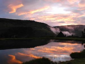 ein Spiegelbild des Himmels in einem Teich bei Sonnenuntergang in der Unterkunft Mount Sheba Rainforest & Resort Self Catering Cottages in Pilgrimʼs Rest
