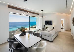 un soggiorno con tavolo e sedie bianchi di Aeliades Villas a Ayios Nikitas