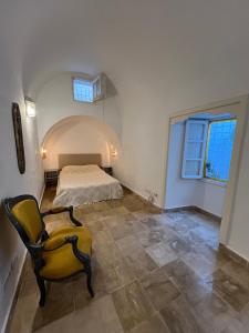 西迪·布·赛义德DAR ZAHRA Sidi Bou Said的一间卧室，有一张床和一把黄色椅子