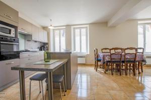 Una cocina y un comedor con mesa y sillas. en La maison d'a cote, en Crancey