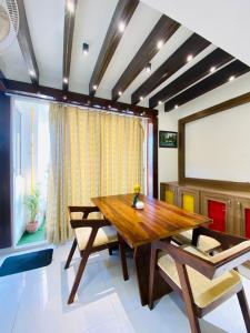 a dining room with a wooden table and chairs at luxury Jaipur Jewel near airport by Akira Homes in Jaipur