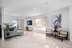 a large living room with a couch and chairs at Coastal Central 3BR - Spa, Surfers Paradise, AC in Gold Coast