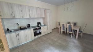 a kitchen with a sink and a table with chairs at Dom Studencki Babilon in Poznań