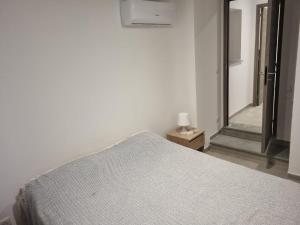 a white bedroom with a bed and a mirror at Maison Samuela in Grillasca