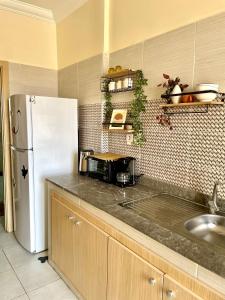 a kitchen with a white refrigerator and a sink at Appartement cosy 2 min aéroport Marrakech 2 chambres bien équipé in Marrakech +5 photos