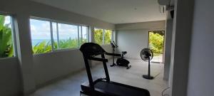 a gym with two exercise bikes in a room with windows at Blue Bay Villa in Haad Yao