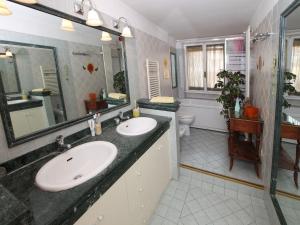 łazienka z dwiema umywalkami i dużym lustrem w obiekcie Angelo Emo Home w Rzymie