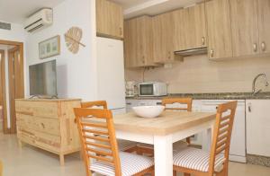 a kitchen with a wooden table and chairs at Apartamento San Sebastian III in Conil de la Frontera +3 photos