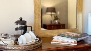 a coffee maker and books on a table in front of a mirror at Upper Classic in Clarens +54 photos