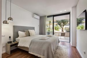 a bedroom with a large bed and a large window at Del Mar Apartment - BT in Olhão +35 photos