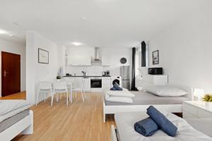 a white living room with white furniture and a kitchen at MONTEUR - Unterkunft für bis zu 5 Personen in 64546 Mörfelden-Walldorf - GG11 in Mörfelden-Walldorf