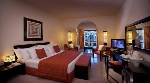 a hotel room with a large bed and a television at Sentido Reef Oasis Aqua Park Resort in Sharm El Sheikh