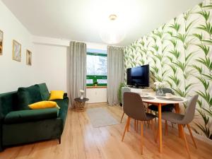 a living room with a green couch and a table at Apartament w Sosnowym SPA in Serock