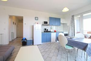 a kitchen and living room with a table and chairs at Apartments Tamara 2397 in Fažana