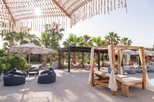 a pavilion with swings and chairs and palm trees at Achilleas Beach Hotel Adults Only in Mastihari +88 photos