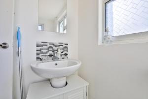 a white bathroom with a sink and a mirror at The Wishing Well- Lovely Spacious Home In BS4 Sleeps 8 By STAE- Homes in Bristol