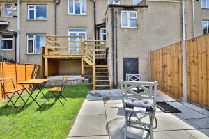 a patio with a wooden staircase and chairs in front of a building at The Wishing Well- Lovely Spacious Home In BS4 Sleeps 8 By STAE- Homes in Bristol