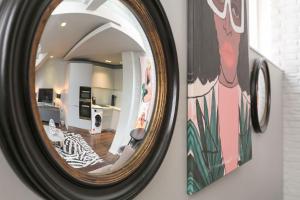 uno specchio appeso a un muro accanto a un soggiorno di The Editorial - Covent Garden By Frankie Says a Londra