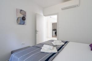 a white room with a bed with towels on it at Villa DE Luna Istra,whirlpool in Barban