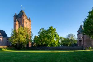 an old castle with a tower on a grass field at Urlaub im historischen Torschreiberhaus in Xanten