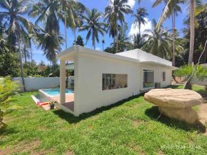 una piccola casa bianca con piscina e palme di Oasis Road a Hinkong