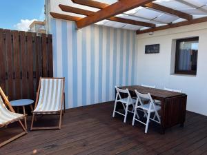 a wooden table and chairs on a deck at Avô Moreira Beach House in Póvoa de Varzim