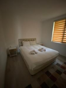 een slaapkamer met een groot wit bed en een raam bij Demre Beyhan Apart in Demre