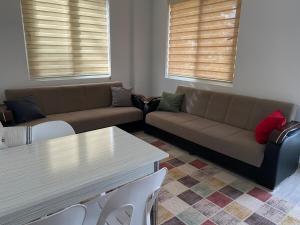 een woonkamer met een bank, een tafel en stoelen bij Demre Beyhan Apart in Demre