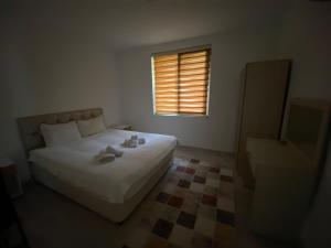 een slaapkamer met een wit bed en een raam bij Demre Beyhan Apart in Demre