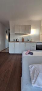 a kitchen with white cabinets and a large bed at House Baglija in Lumbarda