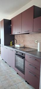 a kitchen with purple cabinets and a stove at House Baglija in Lumbarda