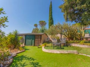 a garden with a table and chairs in a yard at Chez Chris in Fréjus