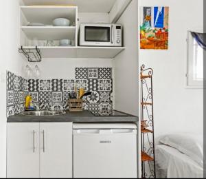 a small kitchen with a sink and a microwave at Chez Chris in Fréjus