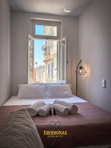 a bedroom with a bed with towels and a window at Erodionas Serenity - Corfu Town Studio in Ágios Rókkos +38 photos