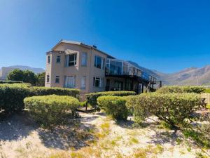 a building with bushes in front of it at Dune Lodge in Hout Bay