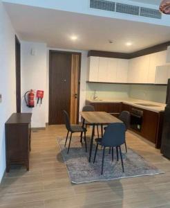 a kitchen with a table and chairs in a room at شقة فندقية بمنتجع ميلينيوم in Salalah