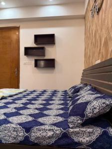 1 dormitorio con 1 cama con edredón azul y blanco en Zoom The Luxury Studio, en Noida