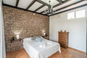 ein Schlafzimmer mit einem Bett und einer Ziegelwand in der Unterkunft Casa Rural La Perla in La Puebla de Cazalla + 37 Fotos