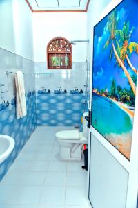 a bathroom with a large screen tv in a white bathroom at Osha Villa in Aluthgama