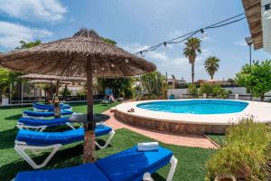 eine Reihe blauer Liegestühle und ein Sonnenschirm neben einem Swimmingpool in der Unterkunft Casa Rural La Perla in La Puebla de Cazalla