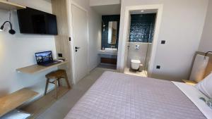 a bedroom with a bed and a bathroom with a sink at Spitaki Among Olives in Tsoukaladhes